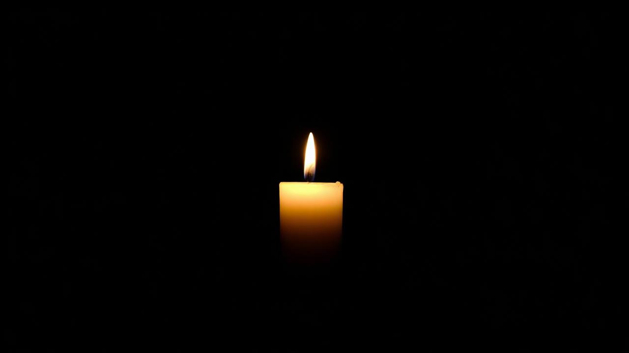 A single candle softly glowing in darkness